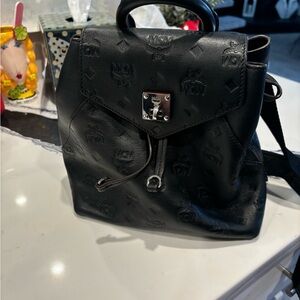 Black leather MCM backpack which converts to a Crossbody monogram bag.